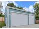 Exterior of the garage showcasing three car bays and blue siding with white trim at 6651 S Dudley Ct, Littleton, CO 80123