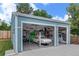 Spacious three car garage with blue siding and a lift and car inside at 6651 S Dudley Ct, Littleton, CO 80123