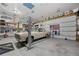 Spacious garage featuring car lift, vintage car, and decorative elements at 6651 S Dudley Ct, Littleton, CO 80123