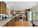 Functional kitchen with stainless steel appliances, wood cabinets, countertops, and modern flooring at 6651 S Dudley Ct, Littleton, CO 80123