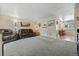Comfortable living room with neutral walls, gray carpet, and adjacent dining area at 6651 S Dudley Ct, Littleton, CO 80123