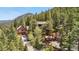 Mountain home surrounded by tall trees features a circular deck and an attached guest house at 4618 Se Summit Trl, Evergreen, CO 80439