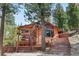 Inviting exterior view showcasing tall ceilings, large windows, and access to a spacious outdoor deck at 4618 Se Summit Trl, Evergreen, CO 80439