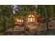 Charming wood cabin nestled among the trees with a stone patio and brick stairs leading to the entrance at 4618 Se Summit Trl, Evergreen, CO 80439