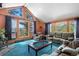 Cozy living room with vaulted ceilings, a wood burning stove, and large windows overlooking trees at 4618 Se Summit Trl, Evergreen, CO 80439