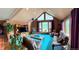 Bright living room with a vaulted ceiling, wood stove, and expansive windows framing the natural beauty at 4618 Se Summit Trl, Evergreen, CO 80439