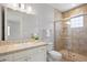 Bathroom features a vanity with stone countertops, a large mirror, and a tiled shower with a glass door at 2500 S Monroe St, Denver, CO 80210