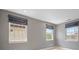 Bedroom with gray walls and carpeting, and three windows, each dressed with Roman shades at 2500 S Monroe St, Denver, CO 80210