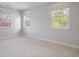 Bright bedroom featuring plush carpet, three windows, and neutral finishes at 2500 S Monroe St, Denver, CO 80210