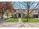 Charming two-story home with stucco exterior, well-manicured lawn, and mature trees at 2500 S Monroe St, Denver, CO 80210
