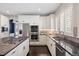 Well-lit kitchen features stainless steel appliances, granite countertops and backsplash, and modern white cabinetry at 2500 S Monroe St, Denver, CO 80210