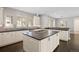 Bright eat-in kitchen with white cabinetry, dark countertops, stainless steel appliances, and a central island at 2500 S Monroe St, Denver, CO 80210