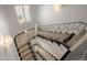 View of the home's staircase with carpeted treads and steel railings, lit by decorative sconces at 2500 S Monroe St, Denver, CO 80210