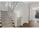 Staircase with carpeted steps, modern metal railing, and hardwood floors at the entry at 2500 S Monroe St, Denver, CO 80210