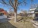 Grass backyard featuring a mature tree, privacy fence, and a brick garage at 3921 N Raleigh St, Denver, CO 80212