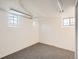 Unfinished basement room with neutral carpet and window light, ready to be customized at 3921 N Raleigh St, Denver, CO 80212