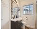 Updated bathroom with designer mirror and window overlooking a brick home at 3921 N Raleigh St, Denver, CO 80212