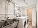 Efficient laundry room featuring a utility sink, modern washer, and dryer at 3921 N Raleigh St, Denver, CO 80212