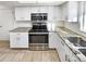 Modern kitchen with white cabinets, granite countertops, and stainless steel appliances at 2500 S Victor St # A, Aurora, CO 80014