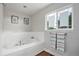 Bright bathroom featuring a soaking tub and window at 10731 E 151St Pl, Brighton, CO 80602