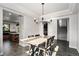 Open dining room with a modern chandelier and stylish chairs, adjoining the kitchen and staircase at 10731 E 151St Pl, Brighton, CO 80602