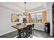Elegant dining room with a modern chandelier, wood accent wall, and a stylish dining table at 10731 E 151St Pl, Brighton, CO 80602