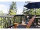 Relaxing deck area with wood furnishings, umbrella, and tree-lined scenery at 20600 Rangeview Dr, Morrison, CO 80465