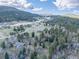 Wide aerial view of the home in a natural mountain landscape with rolling hills at 8473 Gray Fox Dr, Evergreen, CO 80439