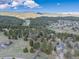 Aerial view of the home in a mountain landscape, surrounded by mature trees at 8473 Gray Fox Dr, Evergreen, CO 80439