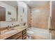 Cozy bathroom featuring a bathtub with shower, vanity with marble countertop, and warm tile work at 8473 Gray Fox Dr, Evergreen, CO 80439