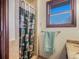 Bathroom with a window and granite topped vanity, plus decorative shower curtain at 8473 Gray Fox Dr, Evergreen, CO 80439