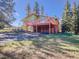 Exterior view of home featuring a deck, attached garage, driveway and natural landscaping at 8473 Gray Fox Dr, Evergreen, CO 80439