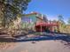 Exterior view of home featuring a deck, stairs, driveway, and garden at 8473 Gray Fox Dr, Evergreen, CO 80439