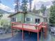 Rear exterior view of home featuring a deck with outdoor seating and natural landscaping at 8473 Gray Fox Dr, Evergreen, CO 80439