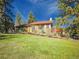 Charming single Gathering home featuring a green exterior, red trim, and a lush front lawn at 8473 Gray Fox Dr, Evergreen, CO 80439