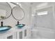 Modern bathroom featuring dual vessel sinks, marble tile, and a shower-tub combo at 18761 E Water Dr # F, Aurora, CO 80013