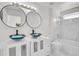 Modern bathroom with dual vessel sinks, marble tile accents, and bright vanity lighting at 18761 E Water Dr # F, Aurora, CO 80013