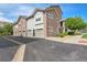 Townhomes with stone facades, light gray siding, individual garages, and manicured landscaping at 18761 E Water Dr # F, Aurora, CO 80013