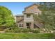Charming townhome featuring a stone facade, private entrances, and lush green landscaping at 18761 E Water Dr # F, Aurora, CO 80013