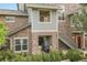 Charming townhome featuring a stone facade, private entrances, and lush green landscaping at 18761 E Water Dr # F, Aurora, CO 80013