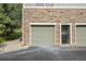View of the garage door and a storage area with a trash can, showcasing the exterior architecture at 18761 E Water Dr # F, Aurora, CO 80013