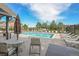 Community pool featuring lounge chairs, tables with umbrellas, and black metal decorative fence at 18761 E Water Dr # F, Aurora, CO 80013