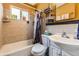 A quaint bathroom features a bathtub, toilet, and vanity with neutral-toned tile work at 1824 S Logan St, Denver, CO 80210