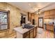 Kitchen with an island cooktop, light-colored wood cabinets, and map-themed wallpaper at 1824 S Logan St, Denver, CO 80210