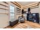 Bright living room featuring hardwood floors, large windows, a piano, and built-in shelving for ample storage at 1824 S Logan St, Denver, CO 80210
