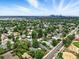 Stunning aerial view of a residential neighborhood with mature trees and a city skyline in the distance at 4968 Alcott St, Denver, CO 80221