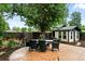 Serene backyard with patio, outdoor dining set, mature trees, and well-maintained landscaping at 4968 Alcott St, Denver, CO 80221