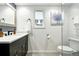 Bright bathroom with a stylish vanity, decorative wall art, and a modern shower with glass enclosure at 4968 Alcott St, Denver, CO 80221
