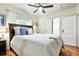 Relaxing bedroom with a cozy bed, ample natural light, ceiling fan and warm wood floors at 4968 Alcott St, Denver, CO 80221