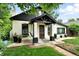 Charming painted brick home featuring a covered front porch with hanging swing at 4968 Alcott St, Denver, CO 80221